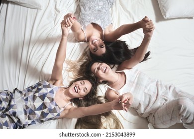  Interracial Group Of Friends Enjoy And Share A Sleepover. Pajama Party With Friends Three Women, Hispanic And Caucasian.