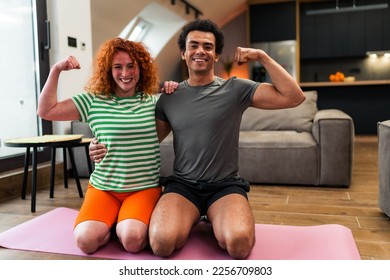 An interracial happy couple showing off muscles,they like to exercise together