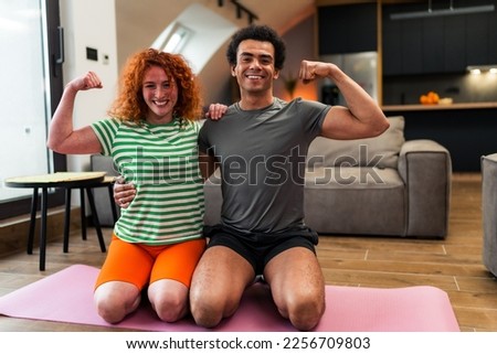 An interracial happy couple showing off muscles,they like to exercise together