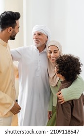 interracial muslim family embracing while looking at each other at home
