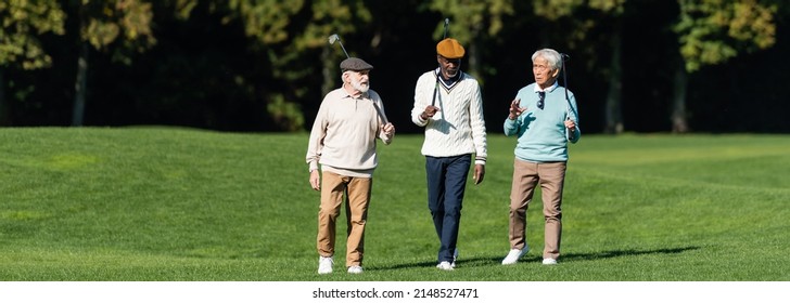 Interracial Senior Friends Walking With Golf Clubs On Field, Banner