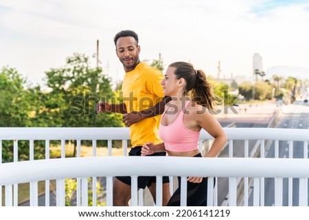 Interracial sportive couple running outdoors - Multiracial couple of runners wearing sportswear and doing functional workout outdoors to strenght body muscles, core abs, stamina and cardio