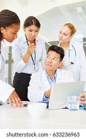 Interracial Team Of Doctors In Training With Tablet Computer In Medical School