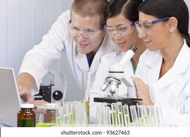 Interracial team of male and female medical or scientific researchers or doctors using a laptop & microscope in a laboratory. - Powered by Shutterstock