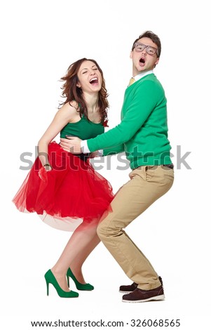 Interracial weird nerd couple dancing together. Caucasian young man wearing eyeglasses and smiling asian woman screaming and wearing 50 style clothes. Fifties nerd concept