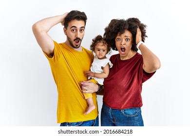 Interracial Young Family Of Black Mother And Hispanic Father With Daughter Crazy And Scared With Hands On Head, Afraid And Surprised Of Shock With Open Mouth 