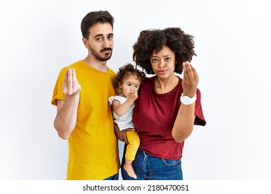 Interracial Young Family Of Black Mother And Hispanic Father With Daughter Doing Italian Gesture With Hand And Fingers Confident Expression 