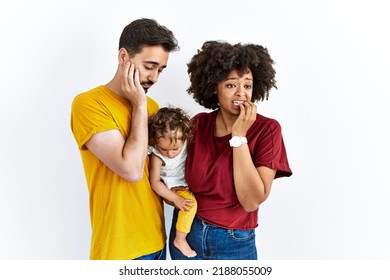 Interracial Young Family Of Black Mother And Hispanic Father With Daughter Looking Stressed And Nervous With Hands On Mouth Biting Nails. Anxiety Problem. 