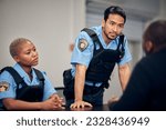 Interrogation, arrest and police team with a suspect for questions as law enforcement officers. Security, crime or investigation with a serious man and woman cop talking to a witness for information