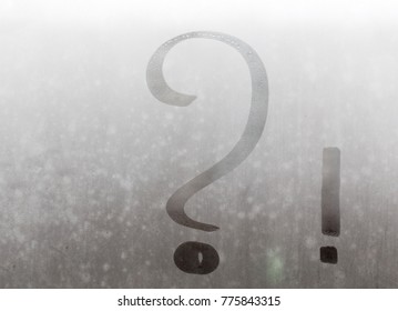 Interrogatory and exclamation marks written on the misted glass.