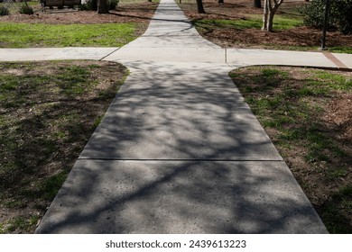 Intersecting sidewalks with one in deep shadows and one in bright light, choices, good and bad, horizontal aspect