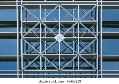 Intersection bars of metal in a geometric pattern in from of a glass wall