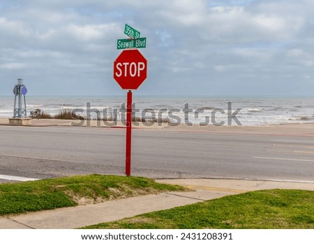 Intersection of Seawall Blvd. and 35th Street on Galveston Island. The Gulf of Mexico is in the background. Stop sign at intersection. 