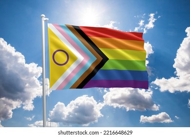 Intersex-inclusive Pride Flag. New LGBTQIA+ Progress Pride Flag. Progress Flag Symbol In The Lgbt Community. Blue Sunny Sky With Clouds.