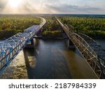 Interstate 20 bridge (left), opened in 1973, and the old highway 80 bridge (right), opened in 1930, crossing the Mississippi River at Vicksburg, MS and headed into the Louisiana delta at sunset.