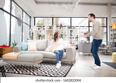 Intersted In Buying. Couple Discussing Furniture Models In A Modern Furniture Shop