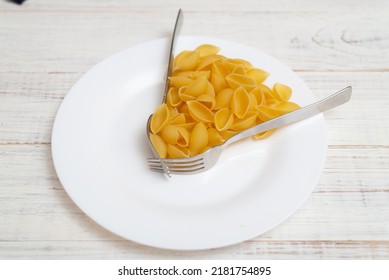 Interval Eating, Fasting, Diet Concept. Conditional Image Of The Time Of Eating Pasta And Forks On A Plate.