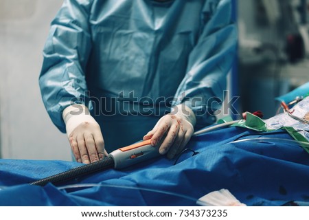 Interventional cardiologist surgeon do AAA endovascular treatment stent graft procedure for abdominal aortic aneurysm repair using wire catheter delivery system for stent with a hydrophilic coating