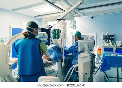 Interventional cardiologist using cardiovascular imaging system with fluoroscopic X-ray tube for interventional vascular procedures, for peripheral exams or electrophysiology. Angiography lab room