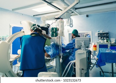 Interventional cardiologist using cardiovascular imaging system with fluoroscopic X-ray tube for interventional vascular procedures, for peripheral exams or electrophysiology. Angiography lab room