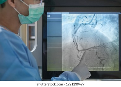 Interventional cardiology. Male surgeon doctor at cardiac catheterization laboratory room.