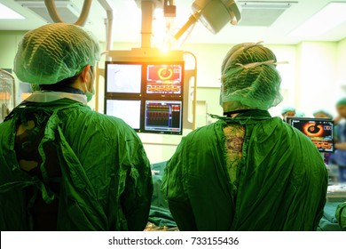 Interventional cardiology. Male surgeon doctor with coronary monitor in operating room.