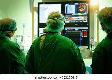 Interventional cardiology. Male surgeon doctor with coronary monitor in operating room.