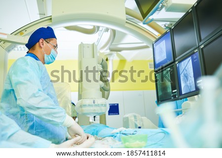 Interventional radiology. surgeon radiologist at operation during catheter based treatment with X-ray visualization.