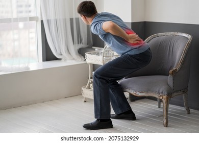 Intervertebral hernia, lumbar pain, kidney inflammation, man suffering from backache at home, spinal disc disease, health problems concept - Shutterstock ID 2075132929