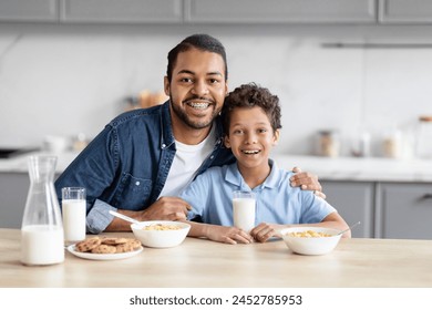 The intimate connection between an african american father and son as they enjoy breakfast together in a kitchen evokes the spirit of family bonds - Powered by Shutterstock