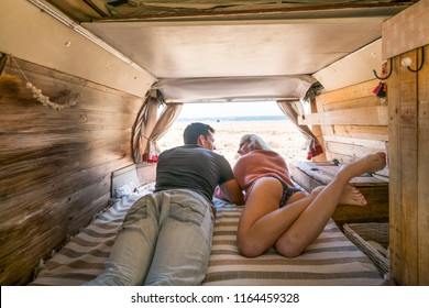 Intimate And Passionate Alternative Classic Hand Made Van Interior With Caucasian Couple Of Traveler Parked In Front Of The Ocean To Enjoy Freedom And Different Tiny House For The Couple. 