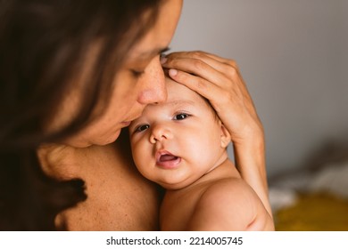 Intimate Portrait Of Hispanic Mother Holding Newborn Baby Daughter In Her Arms Showing Love And Care, With Soft Natural Light. Concept Of Bonding And Motherhood