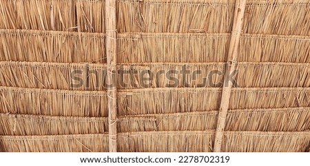 An intimate view of the traditional thatched roofs in a rural village. The thatched roofs can be sun-protected from the rain. And good ventilation. Old hay or dry grass background
