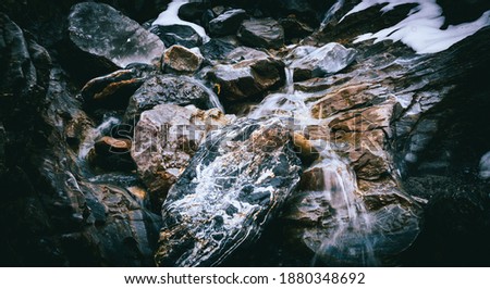 up into the mountain, surrounded by rocks and natural fresh water is coming out of the massive mountain, could be used as background decoration or wallpaper 