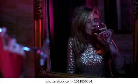 Intoxicated Woman Drinking Wine In Front Of Mirror, Night Club Party, Lifestyle