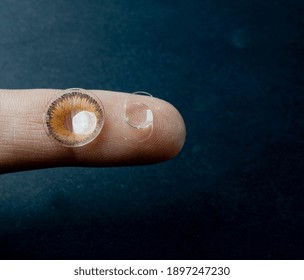 Intra Ocular Lens Of Cataract Surgery And Contact Lens On The Finger Tip