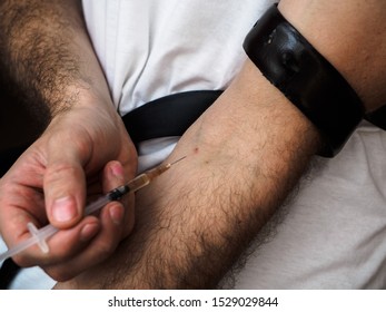 Intravenous Drug Use. A Drug Addict Stabs Himself With A Drug. Imitation