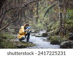 Intrepid Female Biologist Measuring PH Value of Water on Field Directly in Water Stream