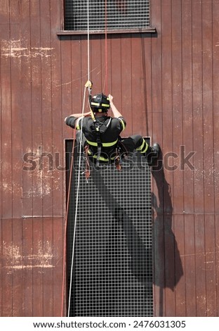 intrepid firefighter lowering himself from the building during the training exercise in the barracks