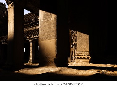 The intricate carvings and shadows in the ancient temple of Angkor Wat, Cambodia - Powered by Shutterstock