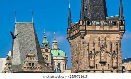 Intricate details of Charles Bridge towers in Prague, Czechia. Gothic architecture, with its pointed spires and ornate decorations. St. Nicholas Church in background. pigeon soars through the sky - Powered by Shutterstock