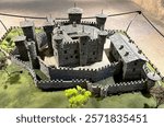 Intricate scale model of Fenis Castle in Aosta Valley, Italy, highlighting its defensive walls, towers, and slate roofs, a testament to medieval architecture