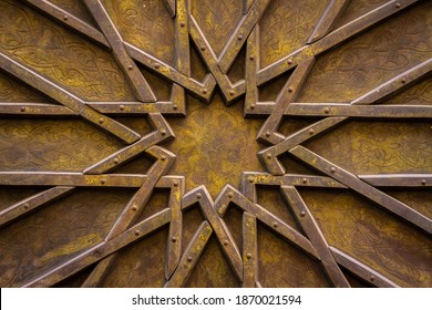 Intricate star shape made out of wooden beams attached to a door and painted gold - Shutterstock ID 1870021594