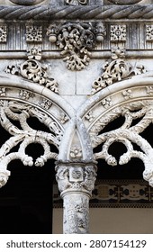 Intricate stonework and windows highlight the unique architecture of Bussaco Palace in Portugal during daylight