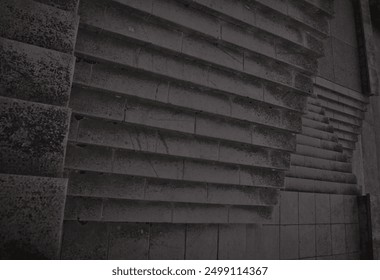Intricately patterned triangular dark moody concrete steps, offering a striking and textured background perfect for various design projects, presentations, and artistic creations.
