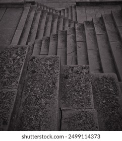 Intricately patterned triangular dark moody concrete steps, offering a striking and textured background perfect for various design projects, presentations, and artistic creations.