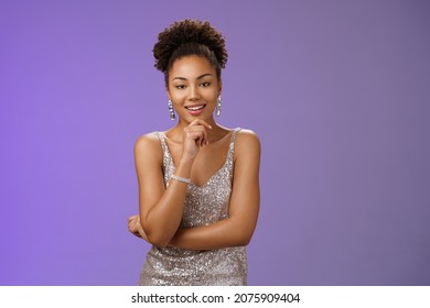 Intrigued creative flirty sensual african woman in elegant stylish silver glittering night dress touch chin thoughtful smirking devious smug have idea plan check out rich man casino, blue background