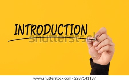 Introduction presentation concept. Male hand draws a line under the handwritten word introduction on yellow background.