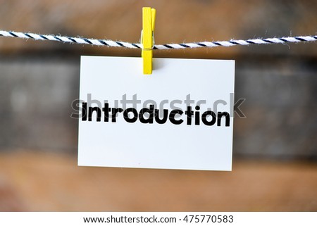 Introduction.Introduction on paper hanging on the clothesline. On old wood background