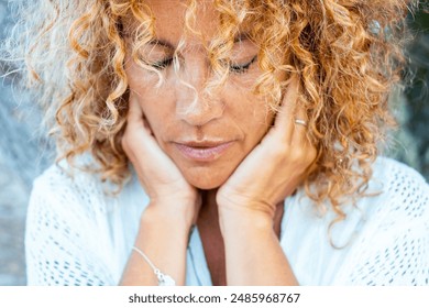 Introspection and meditation concept lifestyle with one woman alone close up portrait touching softly her face with both hands having care. Thoughts and difficulty concept life moments. Female people - Powered by Shutterstock